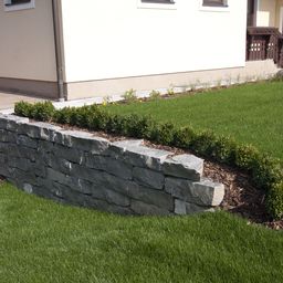 Natursteinmauer in einem Garten.