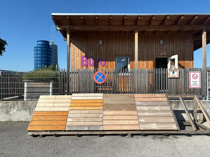 Kleines Bürogebäude mit Ausstellungsstücke von Terrassendielen aus Holz und Hochbeete.