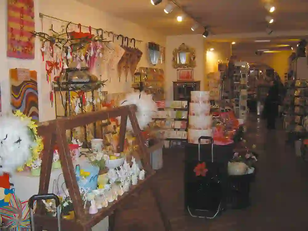 Un intérieur de magasin coloré et accueillant d'Iljos Cucina, qui présente une grande variété de cadeaux et d'articles ménagers dans une atmosphère chaleureuse et intime.