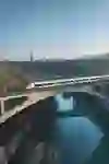 Un treno moderno attraversa il viadotto Lorraine con vista sul centro storico di Berna. L'atmosfera è calma e urbana, con un pizzico di vagabondaggio e di vita quotidiana allo stesso tempo.