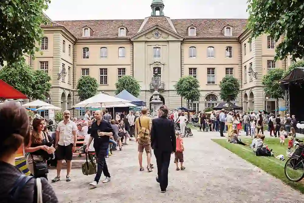 La photo montre la cour intérieure animée de la maison des générations de Berne, un lieu de rencontre et d'échange entre différentes générations.