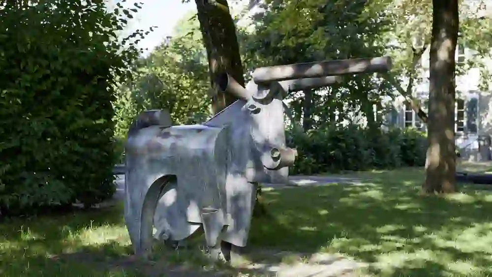 Un tranquillo cortile storico di Berna con un'antica fontana, una scala di metallo ed edifici in pietra arenaria. La scena è affascinante e tipica della città vecchia.