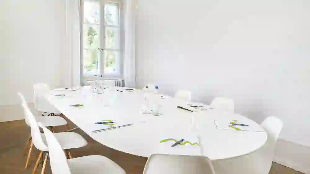 L'immagine mostra una sala seminari luminosa e ben progettata nel ristorante Schöngrün, che crea un'atmosfera di concentrazione e calma grazie al suo design minimalista e alla luce naturale.