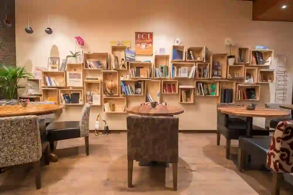 Das Bild zeigt eine behagliche Ecke der Lobby im Hotel Bären am Bundesplatz, die mit Bücherregalen und bequemen Sitzgelegenheiten eine warme, einladende und heimische Atmosphäre ausstrahlt.