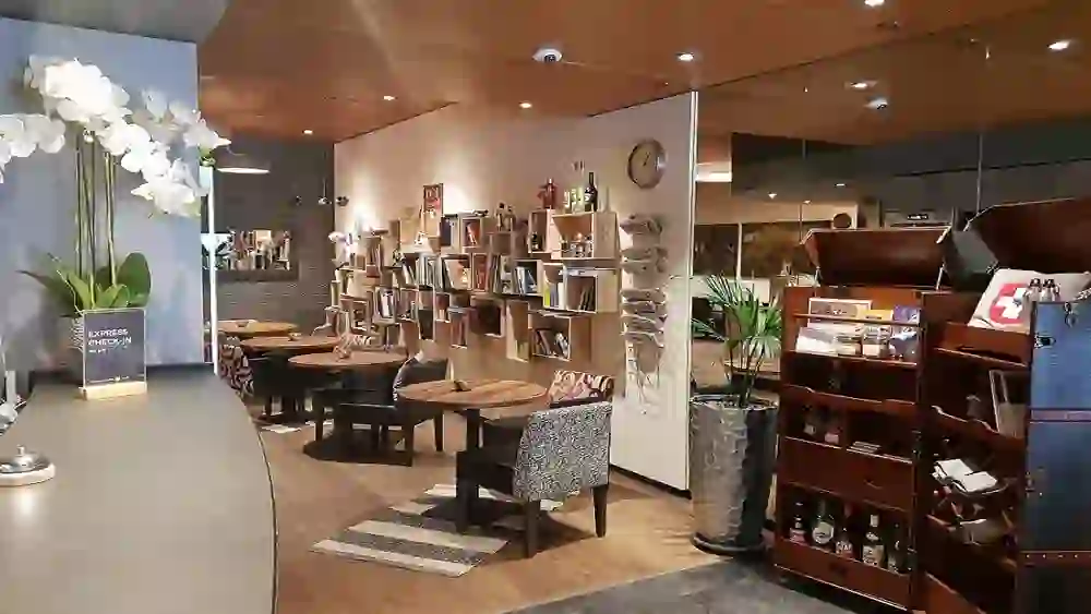 Das Bild zeigt die gemütliche und einladende Lobby des Hotel Bären am Bundesplatz, dekoriert mit Bücherregalen und warmen Beleuchtungselementen, die eine entspannte und heimelige Atmosphäre schaffen.