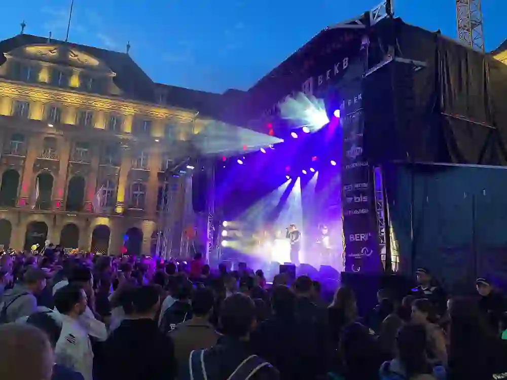 Auf dem Bild ist das Berner Stadtfest zu sehen. Eine Bühne mit einer Band und Zuschauer.
