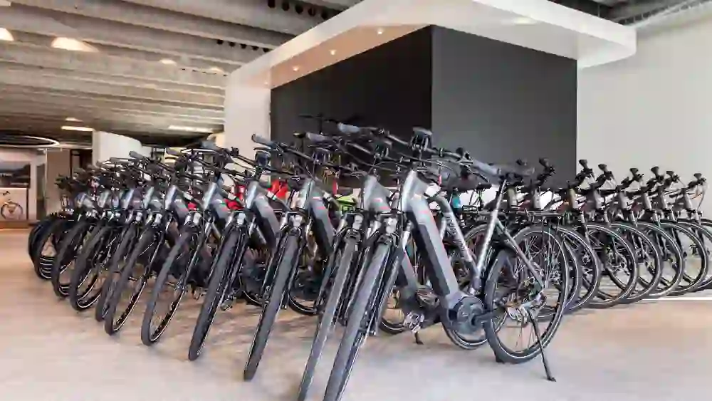 Des rangées de vélos électriques modernes sont prêtes pour l'aventure, dans un espace qui respire l'anticipation et l'attente de nouvelles découvertes sur deux roues.
