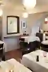 Un restaurant haut de gamme au décor élégant, avec de l'art sur les murs et éclairé aux bougies, qui dégage une atmosphère calme et raffinée.