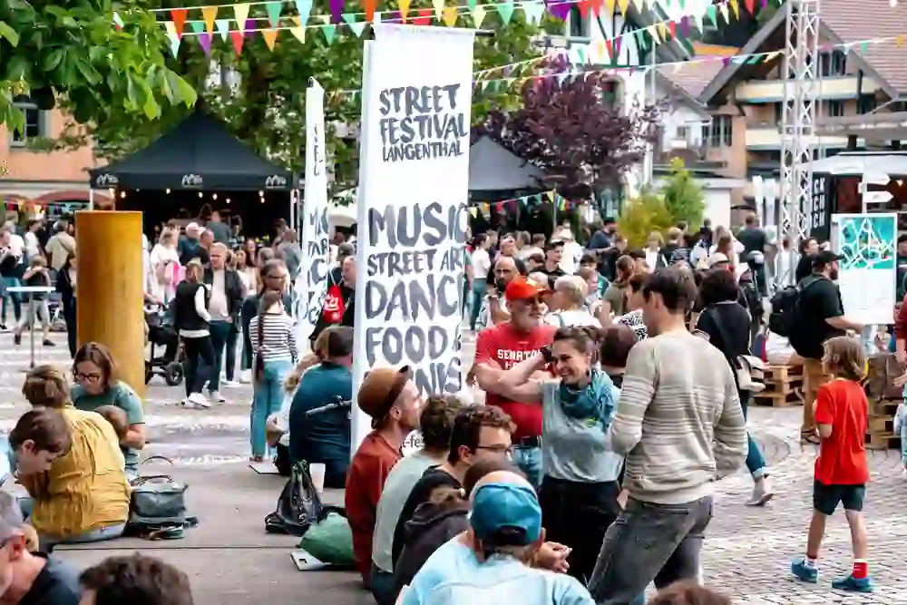 Das Street Festival in Langenthal pulsiert vor Leben: Bunte Wimpel, lachende Gesichter, Musik und Gespräche füllen den Platz. Menschen tanzen, essen, entdecken – ein fröhliches Fest für alle Sinne, das Gemeinschaft und Kreativität zelebriert.