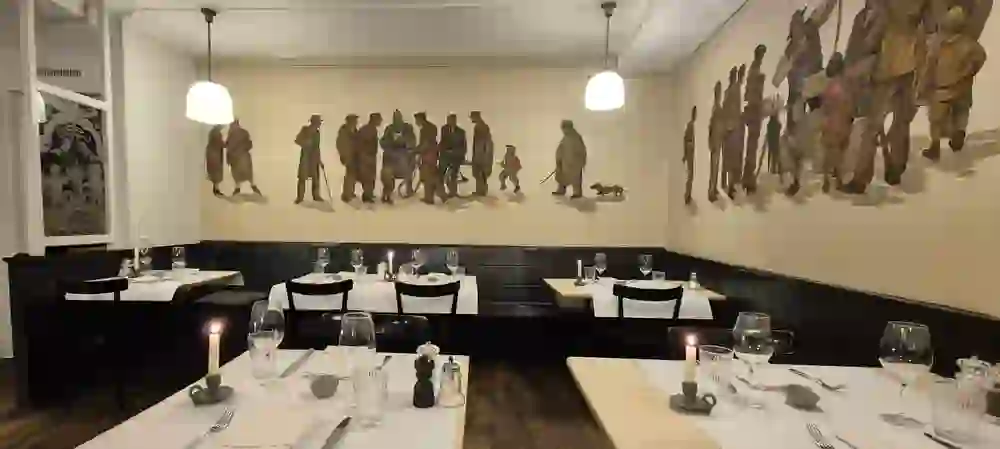 Interior with a special charm: the wall painting with historical scenes gives the dining room a unique identity. The simply laid tables emphasise the traditional ambience.