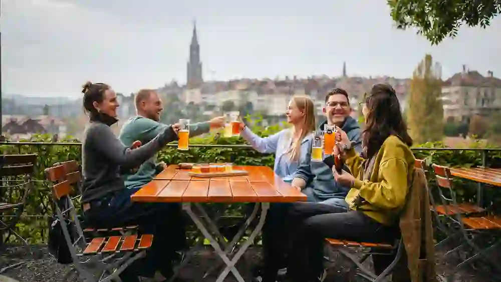 Geniessen Sie mit Freunden ein frisches Bier auf der Terrasse des Alten Tramdepots in Bern, mit einem herrlichen Ausblick auf die Altstadt und den Berner Münster. Ein perfekter Ort zum Entspannen und Plaudern.