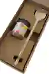 Das Bild zeigt eine einfache, aber sorgfältig verpackte Kochzutat und einen Holzlöffel in einer Box, was eine Einladung zum Kochen und Geniessen in einer warmen, häuslichen Atmosphäre darstellt.