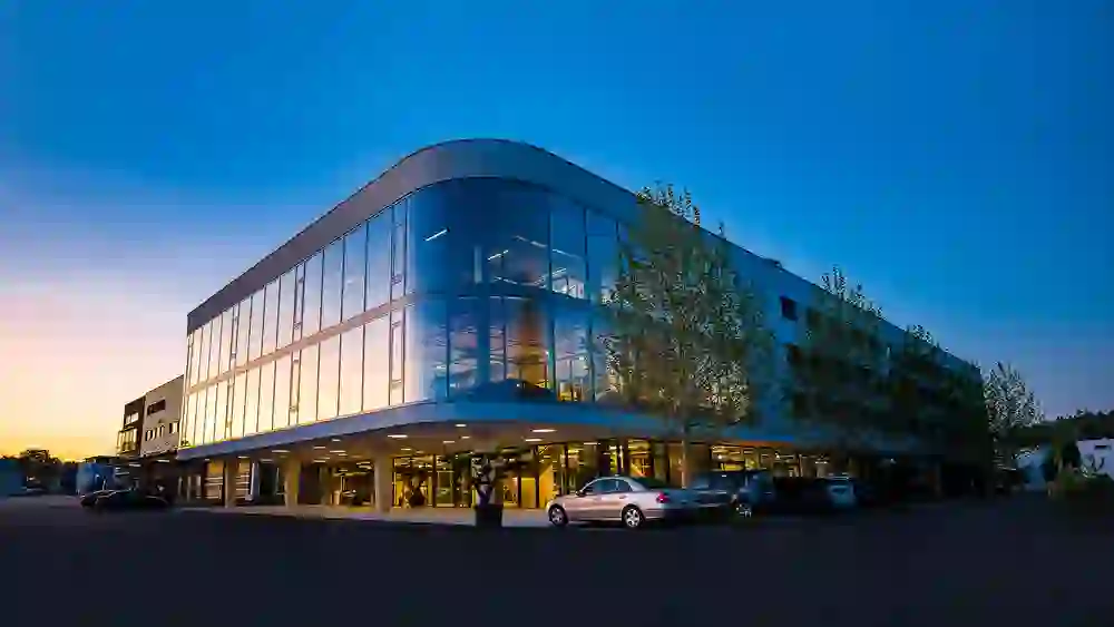 The picture shows the modern Hotel Meilenstein with glass fronts at dusk, which radiates elegant and progressive architecture.