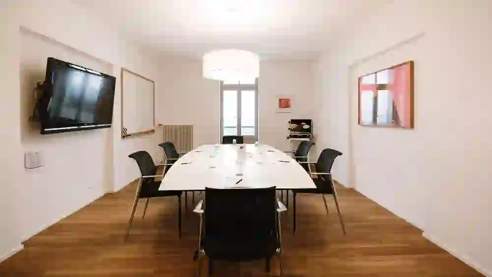 La salle de séminaire du Gurten Park se présente de manière claire et fonctionnelle, avec une longue table pour les réunions, une lumière claire et un équipement moderne. L'atmosphère est concentrée et professionnelle.