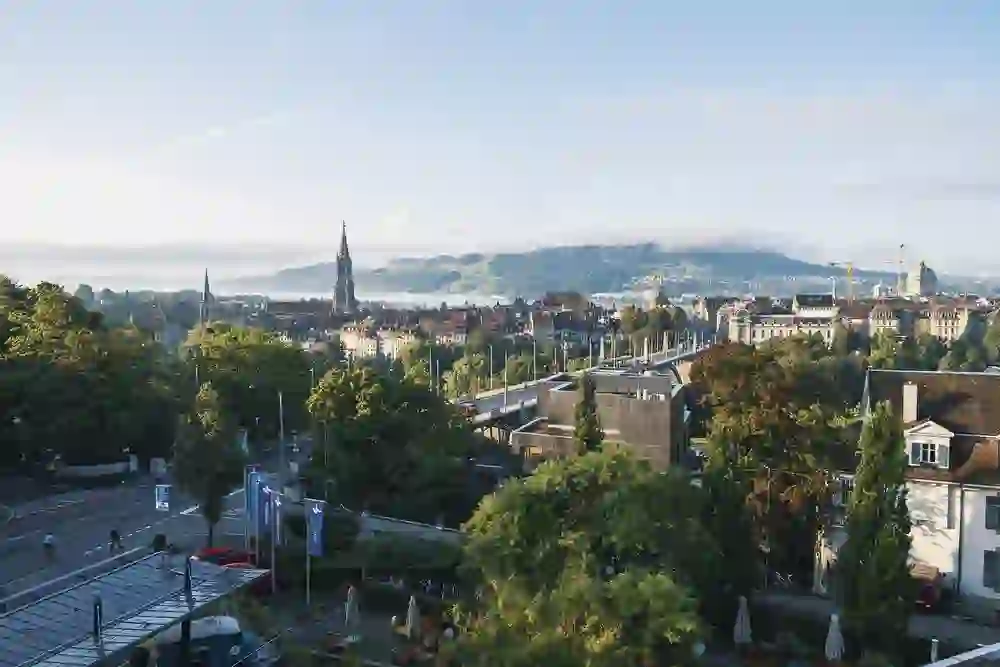 Das Bild zeigt einen atemberaubenden Blick über die Stadt Bern mit historischen Gebäuden und einer umgebenden grünen Landschaft, der Ruhe und Schönheit ausstrahlt.