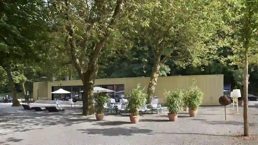 Das Foto präsentiert den ruhige Aussenbereich des Eventraums der Schwellenmätteli Restaurants, versteckt unter schattenspendenden Bäumen, die eine entspannte und friedliche Atmosphäre ausstrahlen.