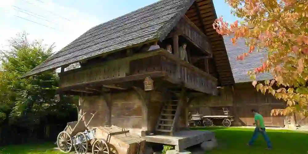 The photo shows the exterior view of the Althuus Farmers' Museum, embedded in a rural setting. You can see a traditional wooden structure typical of rural Swiss architecture.