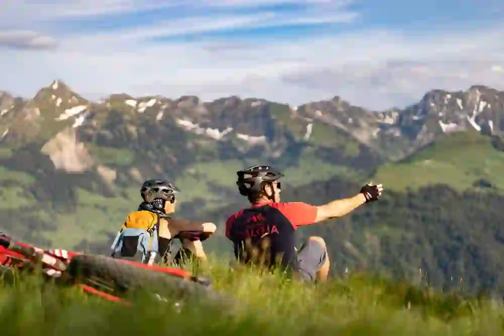 Auf dem Bild sind zwei Personen zu sehen welche genüsslich eine Pause vom Mountainbiken im Naturpark Gantrisch machen