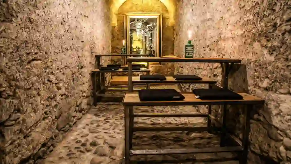 Das Bild zeigt einen intimen Kulturkeller im Hotel Kreuz Herzogenbuchsee, der mit seinen groben Steinwänden und dem warmen Kerzenlicht eine geheimnisvolle und gemütliche Atmosphäre ausstrahlt, ideal für einzigartige Veranstaltungen und Treffen.