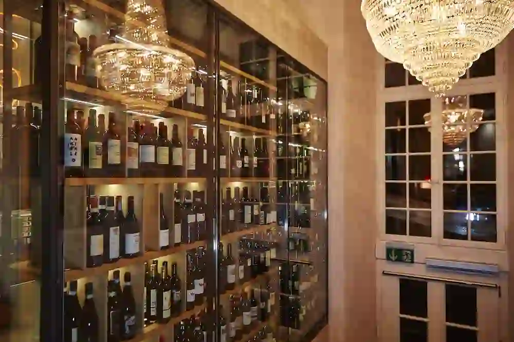 Auf dem Bild ist die Vinothek des Restaurant toi et moi zu sehen, beleuchtet von einem prachtvollen Kronleuchter, der eine warme und luxuriöse Stimmung schafft und die sorgfältig ausgewählten Weine hervorhebt.