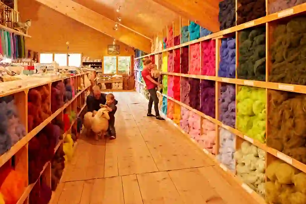 Der lebendige Laden der Spycher-Handwerk AG in Huttwil taucht Besucher in ein Meer aus Farben. Die herzliche, familiäre Atmosphäre wird durch die Freude eines Kindes an einem kuscheligen Spielzeug unterstrichen.