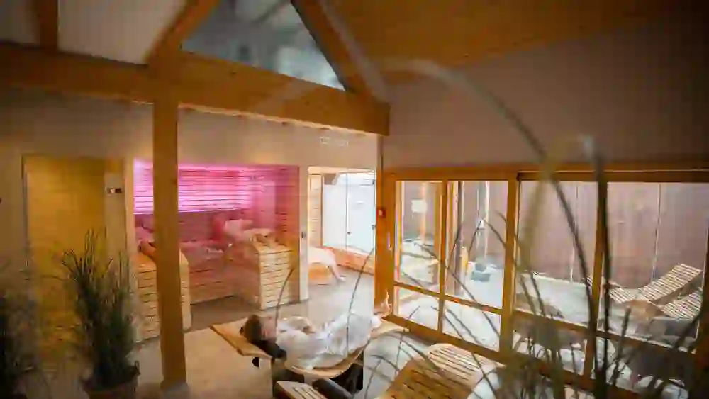 Nell'area benessere del Romantikhotel Bären Dürrenroth, gli ospiti possono godere di pace e tranquillità in una stanza luminosa con elementi in legno. La sauna e le sedie a sdraio offrono un'oasi di relax.