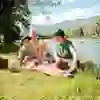 The picture shows a family having a picnic on the River Aare