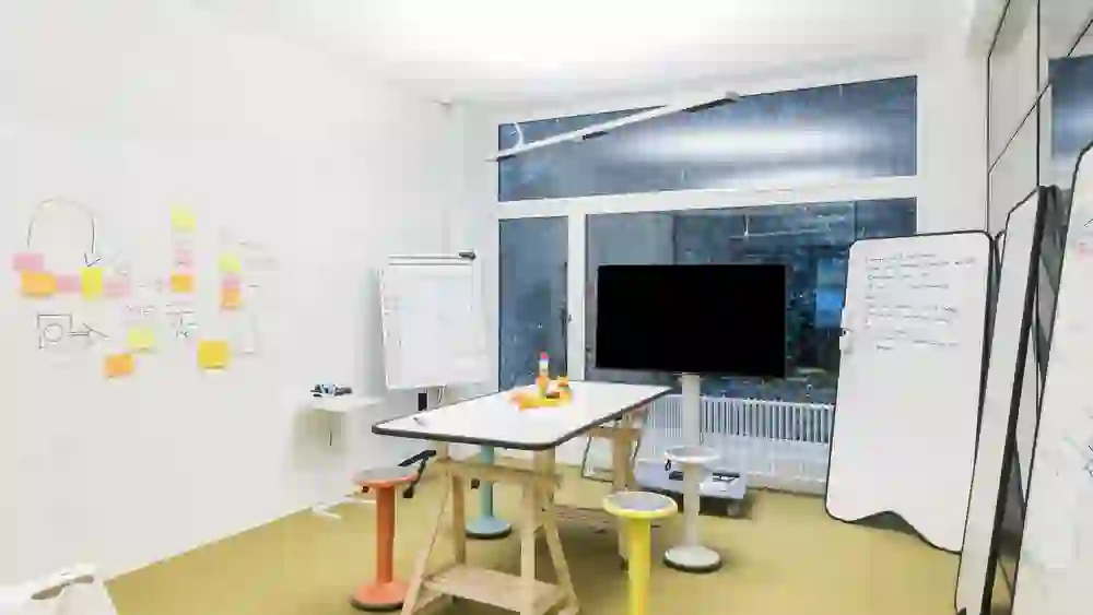 The picture shows the "Challenger" room in INNOSpace, an inspiring and dynamic environment with colourful furniture and ideas sketched on the walls, creating an atmosphere of innovation and collaboration.