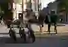 Trois amis traversent en souriant une rue animée de la ville, passant devant une rangée de vélos garés, capturés dans un moment de légèreté et de complicité, accompagnés par le charme urbain et la liberté qu'offre une carte journalière PubliBike.