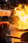 Sur l'image, on voit un cuisinier travailler avec un wok tandis qu'une flamme impressionnante jaillit de la poêle. La chaleur et le feu transmettent la passion et le savoir-faire du cuisinier. L'énergie dans la cuisine est littéralement palpable et donne vie au dynamisme de la cuisine asiatique.