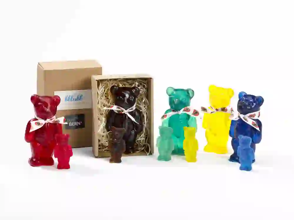 Les savons colorés en forme d'ourson de la manufacture de savon Blubb, présentés à côté d'un emballage, rayonnent de créativité et de joie et invitent à emporter l'expérience olfactive à la maison.