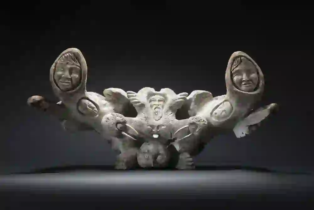 L'opera d'arte della collezione Inuit del Museo Cerny di Berna mostra una scultura dettagliata in cui volti umani e forme animali sono collegati tra loro. I tratti espressivi e il complesso intreccio delle figure catturano l'interesse e raccontano storie della cultura inuit.