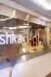 The photo shows the bright and modern Bershka shop in the Wankdorf Centre, alive with the fleeting movements of a customer passing through the transparent, shiny façade, creating a dynamic shopping atmosphere.