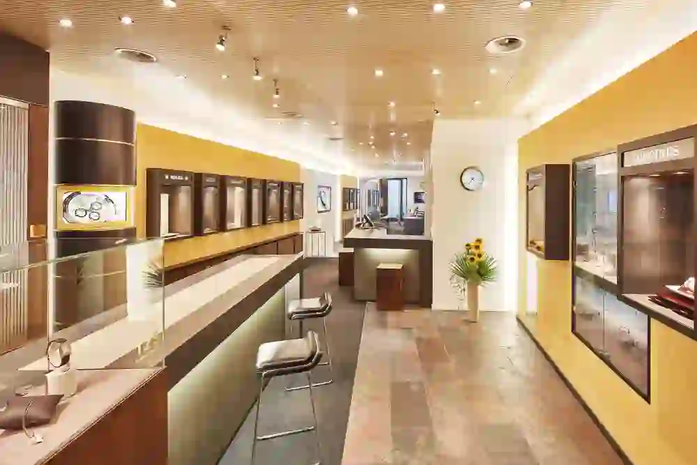 Das Bild zeigt das Innere von Zigerli+Iff in Bern, wo eine warme Beleuchtung und die Kombination aus Holz und warmen Farbtönen eine einladende und komfortable Atmosphäre für Luxusuhrenliebhaber schaffen.