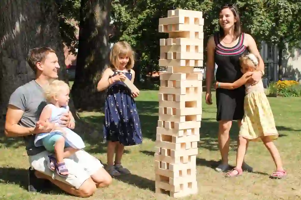 Das Bild zeigt eine Familie, die im Freien gemeinsam spielt, was Teil eines des Ludotrails in Burgdorf ist.