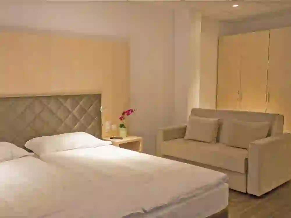 La photo montre une chambre double aménagée avec goût dans l'hôtel Los Lorentos Residences Bern Airport. Les couleurs douces et le mobilier confortable créent une atmosphère calme et accueillante.