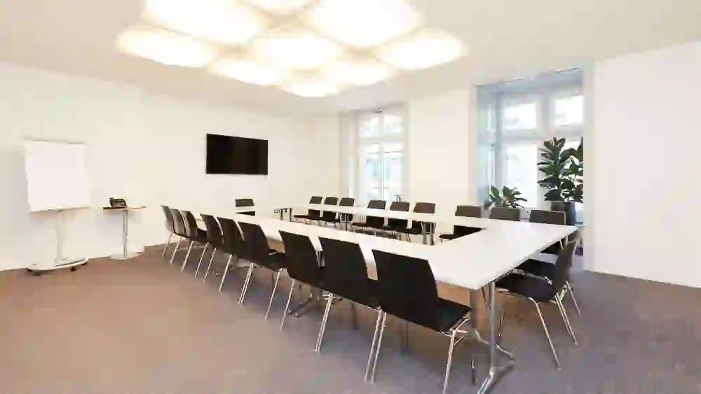 Der Raum im Kongresszentrum Kreuz Bern wirkt mit seiner klaren, funktionalen Einrichtung und dem sanften Licht von oben ruhig und konzentriert, ideal für produktive Meetings.
