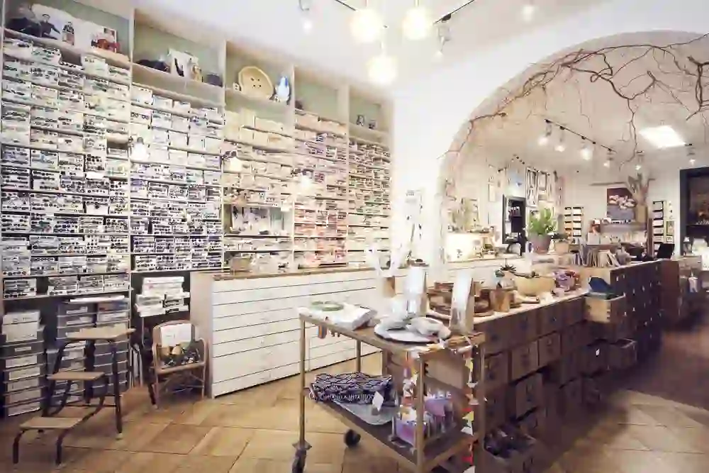 Das Bild zeigt das Innere eines Ladens, des Bazaar 58 , mit einer Vielzahl von Produkten, die ordentlich auf Regalen präsentiert werden. Der Raum ist hell und einladend, mit einer künstlerischen Gestaltung an der Decke und diversen Waren, die zum Verkauf stehen.