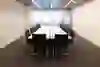 La foto mostra una sala riunioni pulita e ben illuminata, le cui sedie e il tavolo vuoti suggeriscono un'atmosfera di attesa e di potenziale non sfruttato. L'ordine calmo irradia prontezza per le discussioni imminenti.