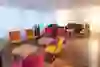 L'image présente un salon chaleureux et accueillant avec des chaises et des canapés colorés qui créent une atmosphère décontractée et confortable pour des conversations détendues.