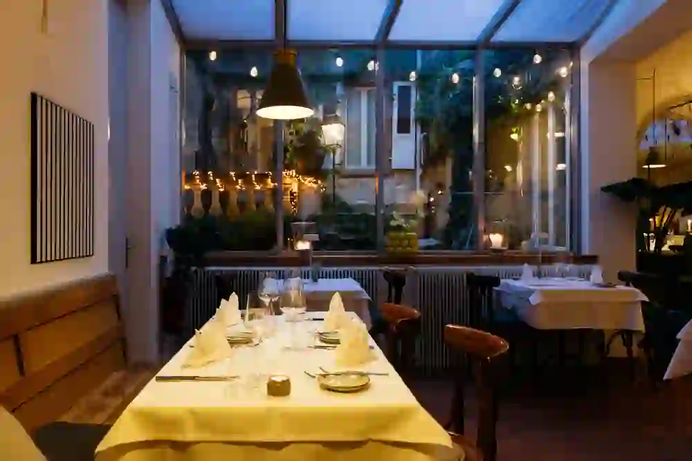 An atmospherically decorated room with candlelight, warm colours and a view of a lovingly illuminated courtyard. The atmosphere is familiar, calm and romantic - a place that immediately makes you feel at home and at ease.