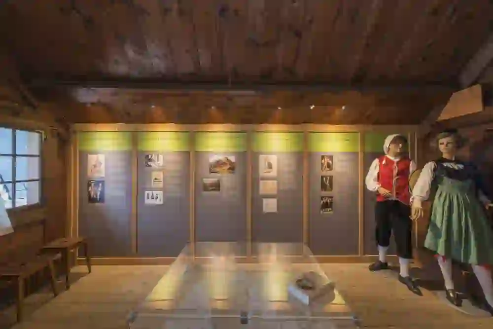 Das Foto zeigt das Innere des Vrenelimuseums in Guggisberg, das einen Einblick in die traditionelle Schweizer Kultur und Tracht bietet.