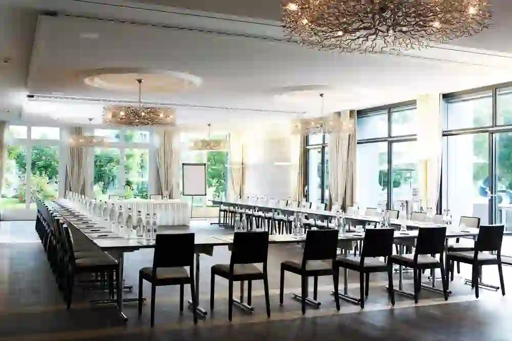 La Haller Saal del Castello di Hünigen è elegante e invitante con lampadari scintillanti, pronta per occasioni di festa e incontri glamour.