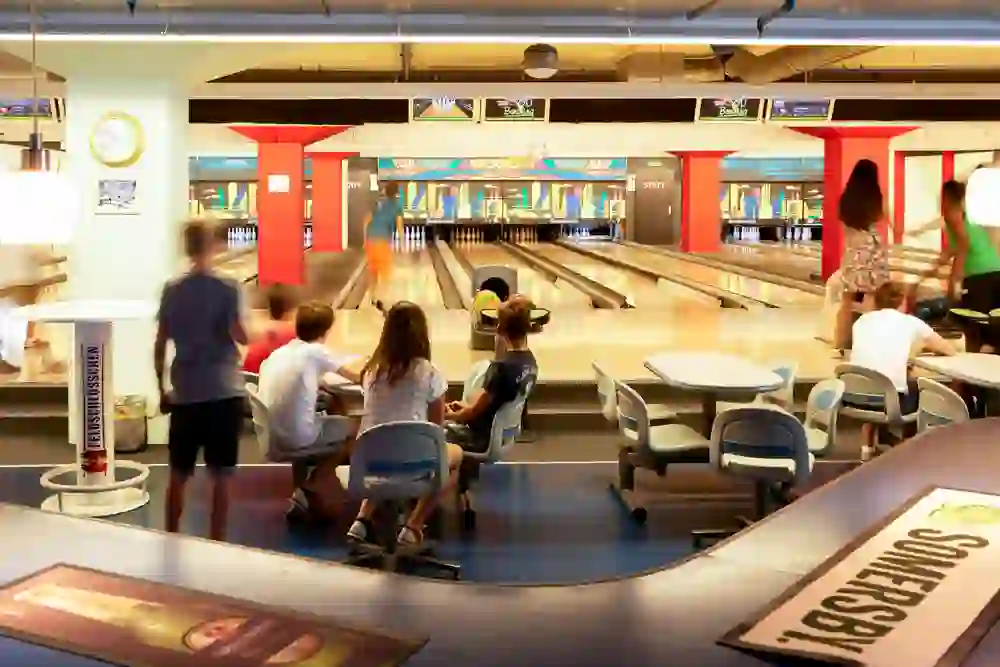 There is a lively and cheerful atmosphere at the Marzili Bowling Centre as children and adults concentrate on the game and the balls roll down the lanes.