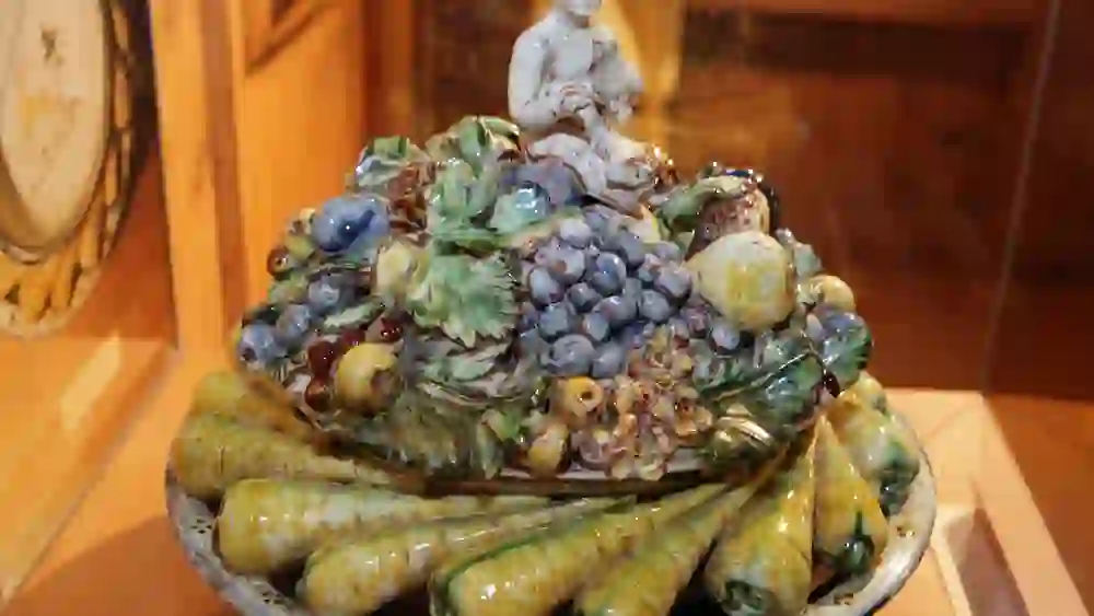 Eine detailreiche Keramikschale, üppig verziert mit Frucht- und Gemüsenachbildungen, birgt eine verspielte Note in der ernsten Umgebung des Regionalmuseums Chüechlihus in Langnau.