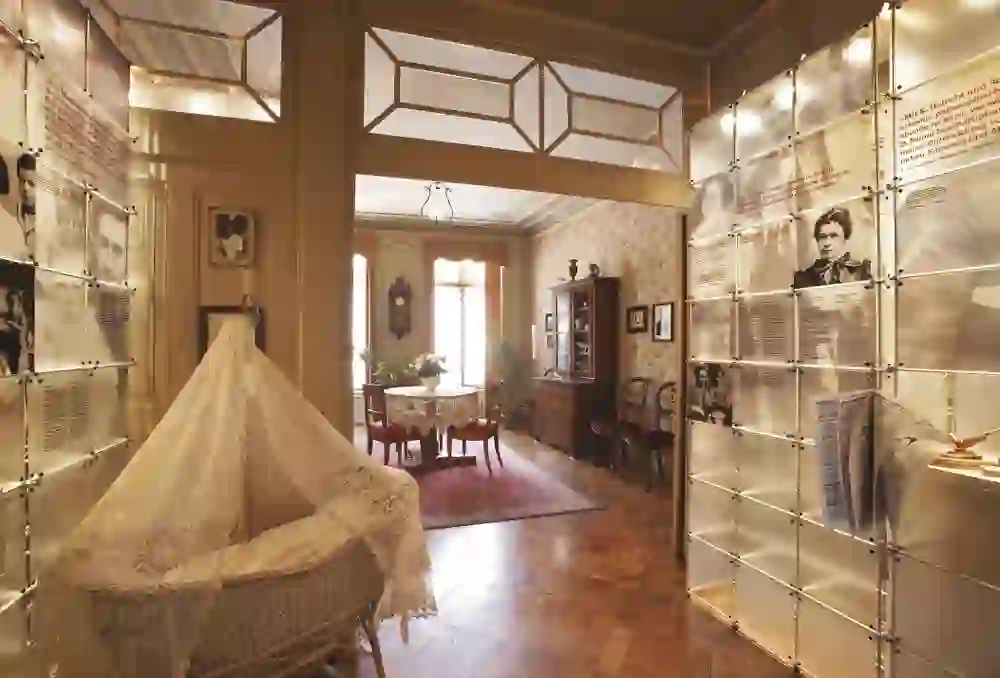 The picture shows an inviting exhibition room with historical furniture, flooded with warm light, which conveys an atmosphere of elegance and education.