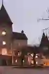 Il castello di Münchenwiler si illumina di luci calde al tramonto, creando un'atmosfera mistica e invitante. L'architettura storica appare particolarmente pittoresca grazie all'illuminazione.