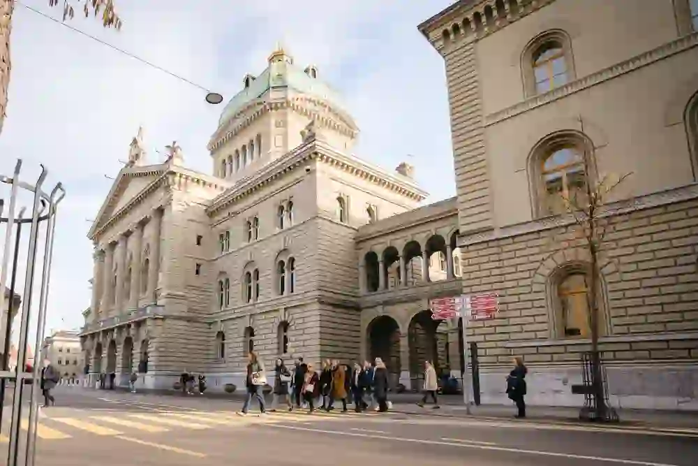 Eine Gruppe geht vor dem imposanten Bundeshaus in Bern entlang, eingetaucht in das historische Ambiente der Stadt, während sie mehr über das Jahr 1848 lernen, als Bern zur Bundesstadt wurde.