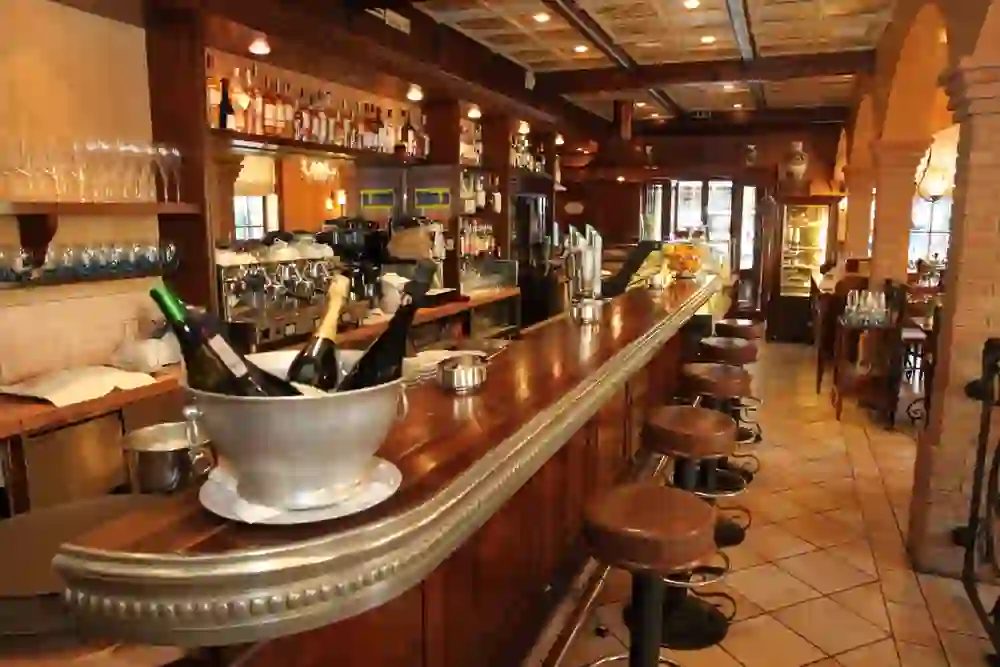 Bar en bois dans un restaurant confortable, prêt pour des moments de convivialité autour d'un verre de vin dans une atmosphère chaleureuse.