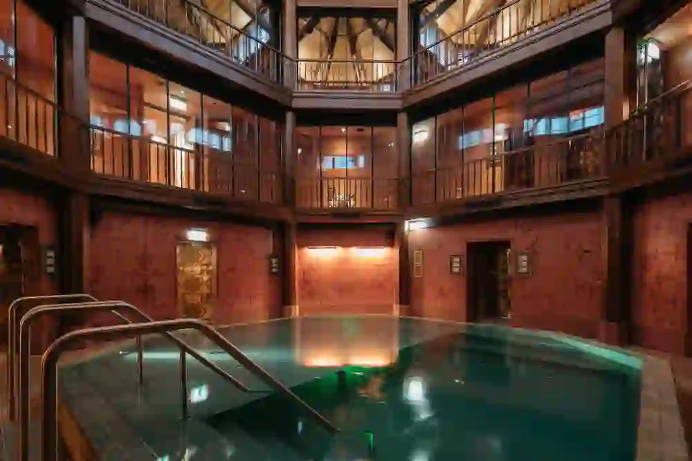 L'intérieur du Hammam & Spa Oktogon à Berne dégage une oasis de calme et de détente avec son intérieur chaleureux en bois et son bassin central.